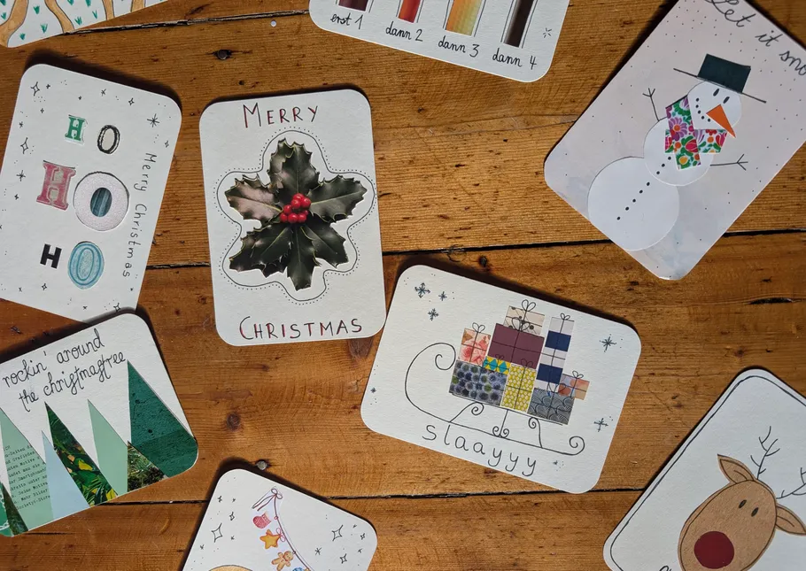 Christmas cards scattered on wooden table.