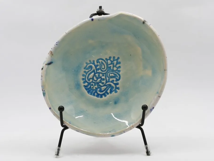 Decorative plate on stand with abstract design.