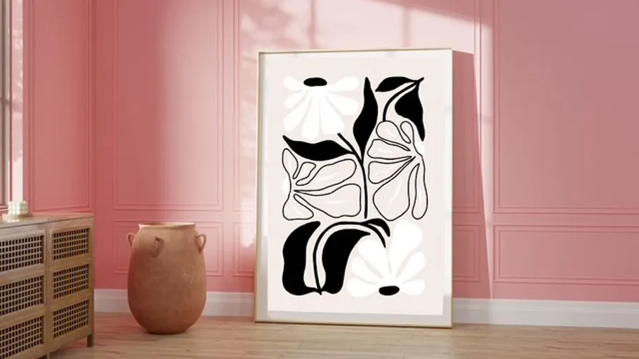 Abstract floral artwork against pink wall.