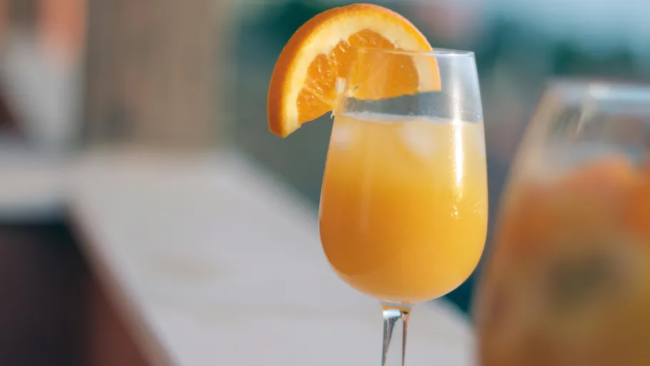 Orange juice in glass with orange slice garnish.