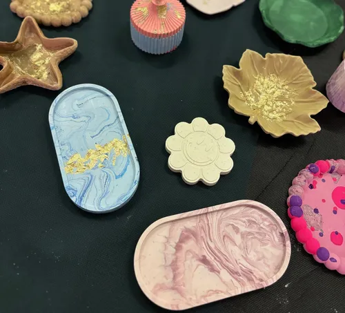 Bunte Tontabletts und Dekorationen auf schwarzem Stoff.