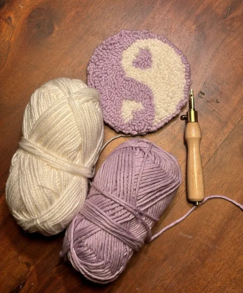Yarn balls, punch needle, yin-yang design.