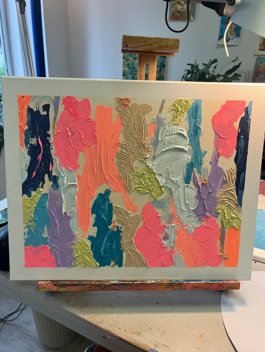 Colorful abstract painting on easel in studio.