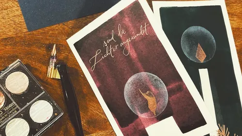 Handmade cards with text, art supplies nearby.