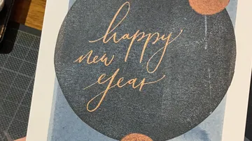 Card with 'happy new year' text on circle.