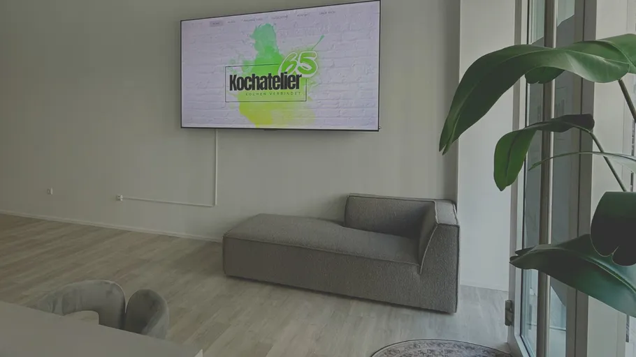 Moderner Raum mit Sofa, Fernseher und Pflanze.