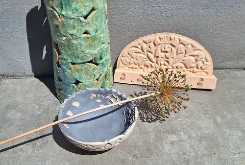 Ceramic objects displayed on concrete floor.