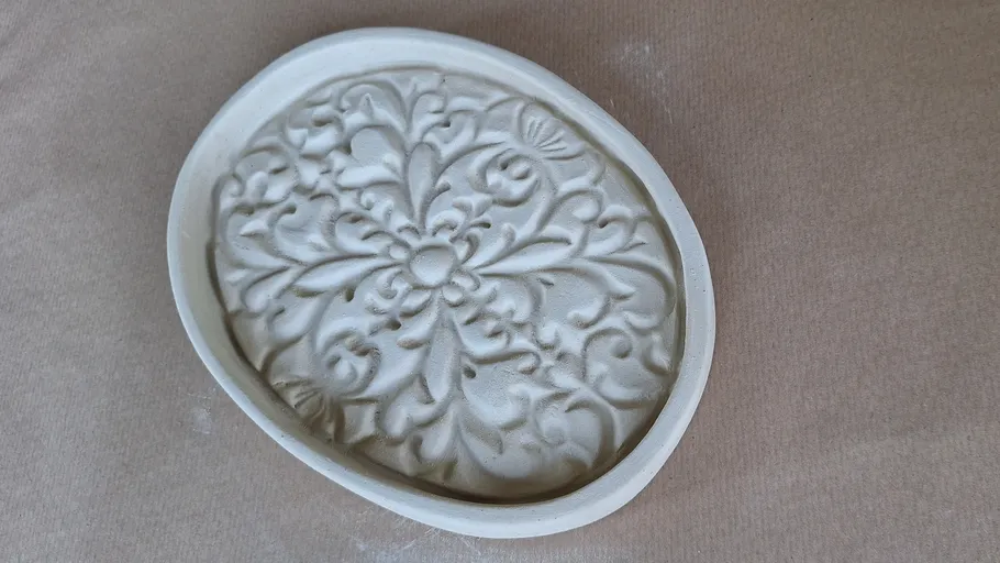 Ornamentierter Stein auf einer flachen Oberfläche.