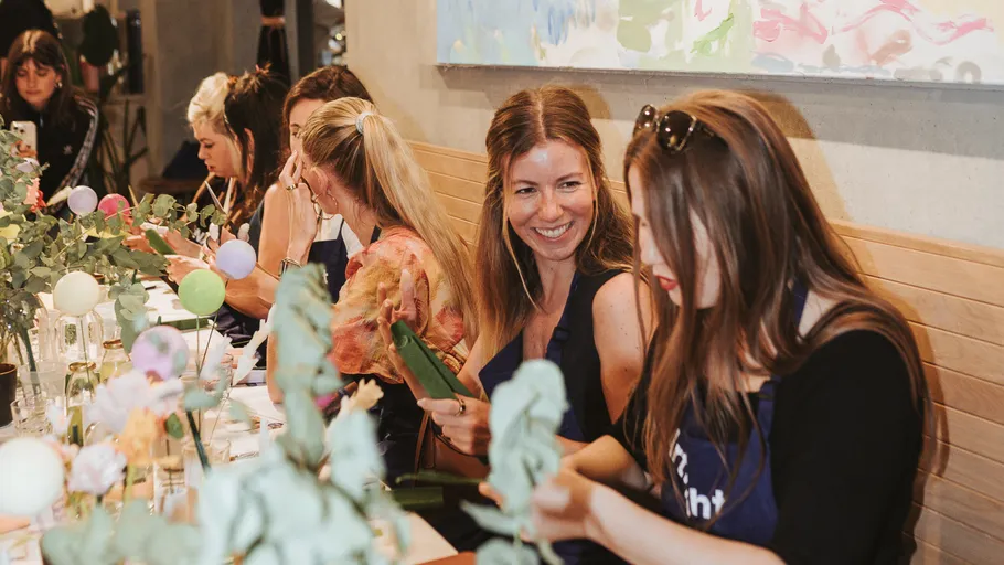 Women crafting together at a decorated table.