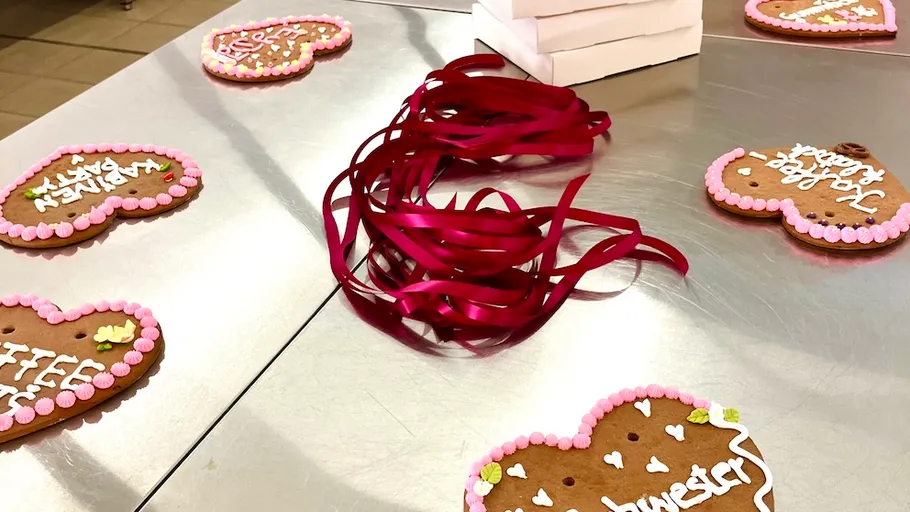 Heart-shaped cookies and ribbons on table.