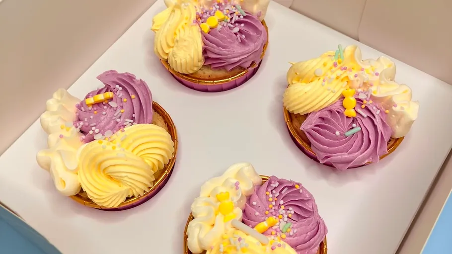 Colorful cupcakes with purple and yellow icing.