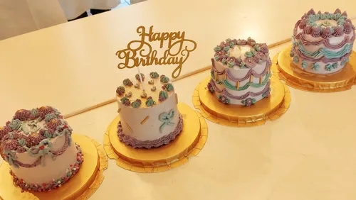 Vier dekorierte Kuchen auf einem Tisch.