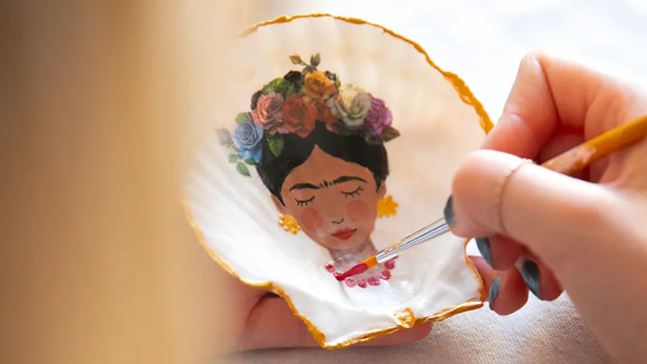 Hand painting Frida Kahlo on scallop shell.