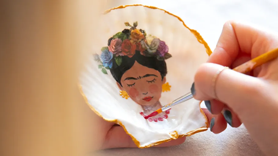 Hand malt Frida Kahlo Porträt auf Muschel.