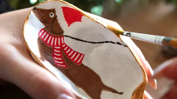 Decorated shell with painting of dog.