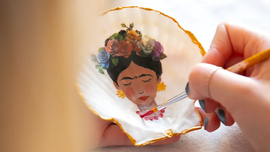 Hand painting face on shell, artistic setting.