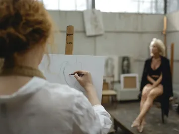 A person draws a sketch of a model.