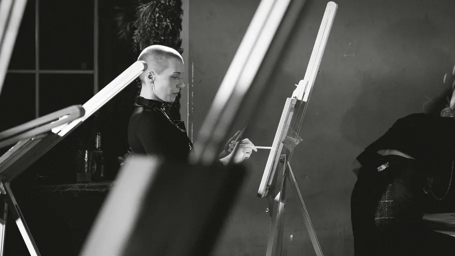 Person painting on canvas in studio setting.