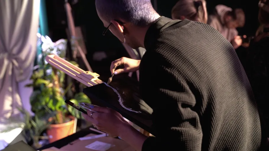 Person malt auf Leinwand drinnen.