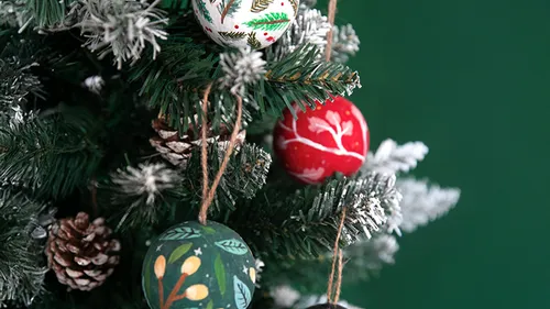 Christmas tree with colorful ornaments and pine cones.