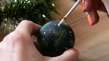 Hand bemalt Weihnachtskugel mit Pinsel.