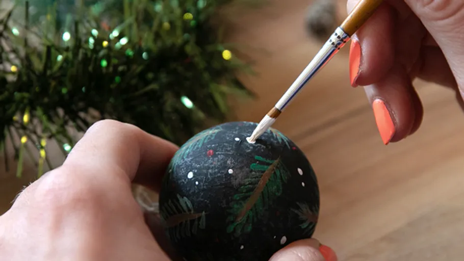 Hand bemalt Weihnachtsschmuck mit Pinsel.
