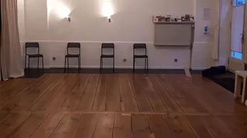 Vier Stühle an der Wand in einem Raum.
