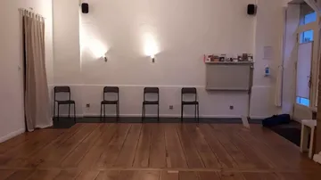 Four chairs against white wall in room.