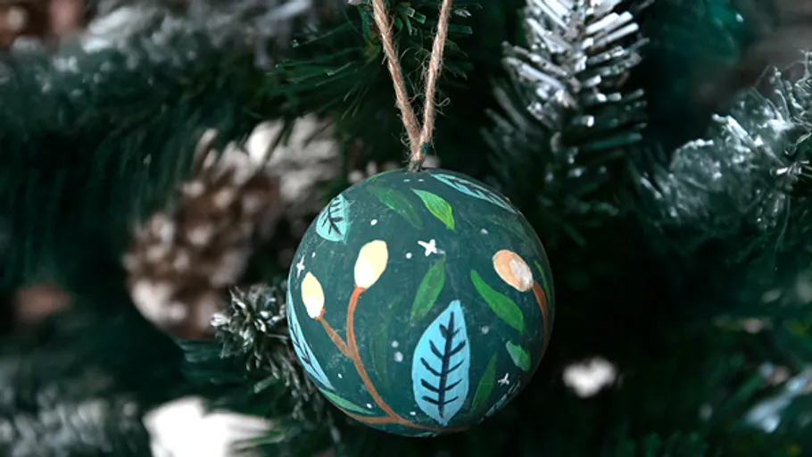 Bemaltes Ornament hängt am Weihnachtsbaum.