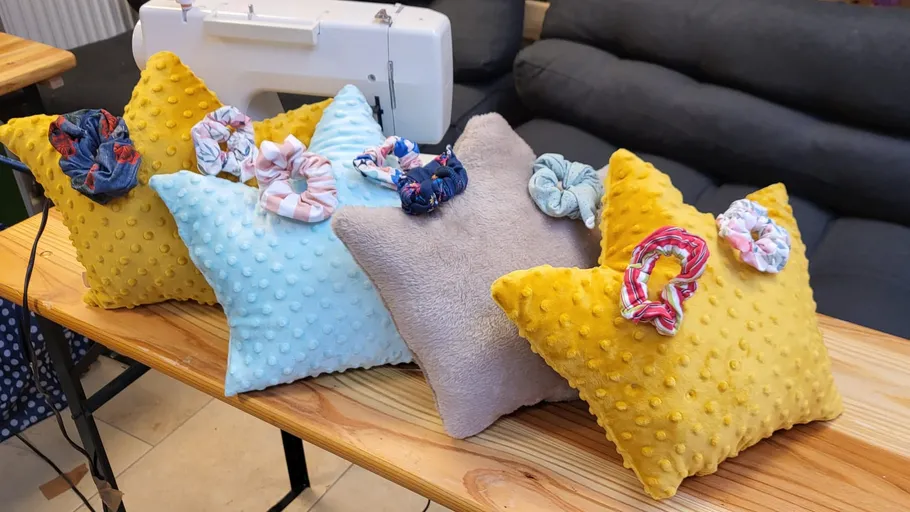 Pillows with scrunchies on a wooden table.
