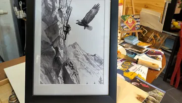 Framed drawing of climber and bird on mountain.