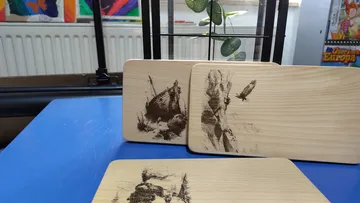 Holzuntersetzer mit Gravuren auf Tisch.
