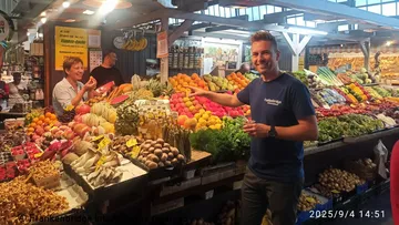 Two people interacting at colorful fruit market.