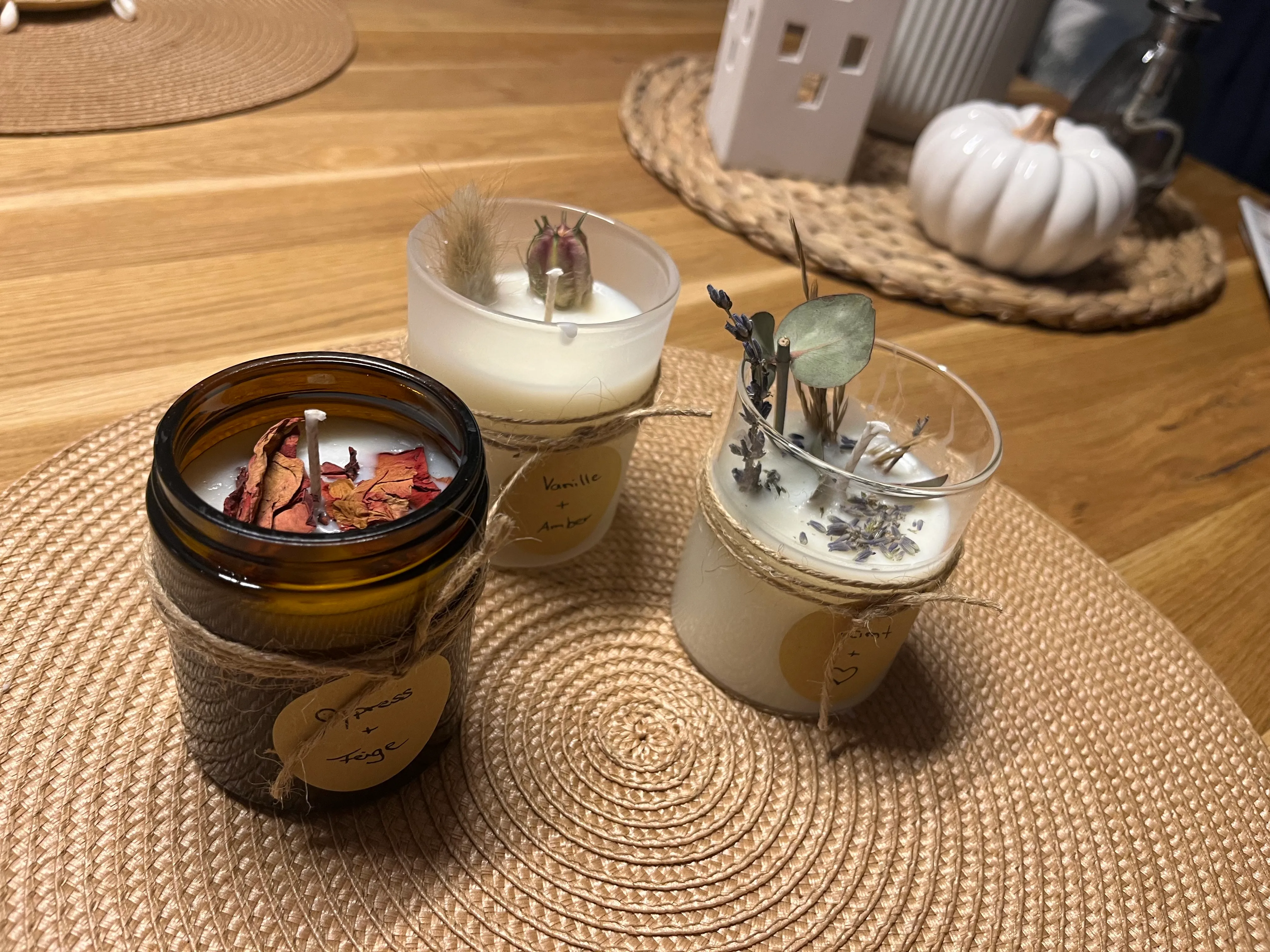 Three scented candles on woven placemat.