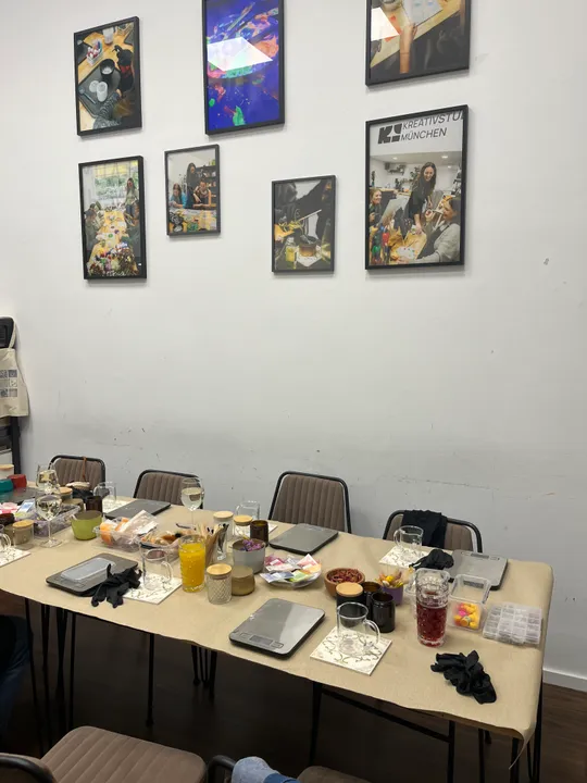 Tische für Bastelworkshop bereit, Fotos an der Wand oben.