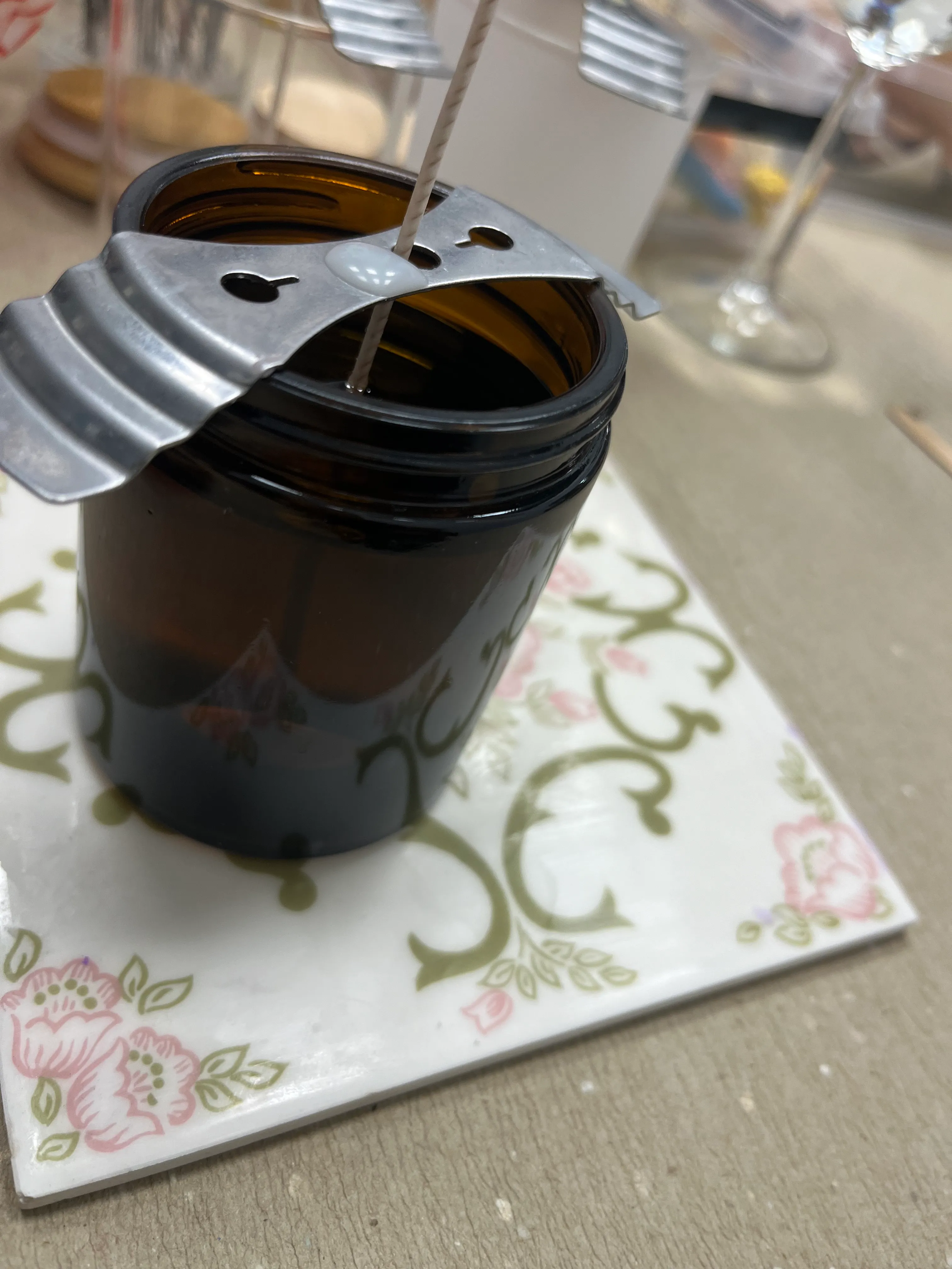 Candle making: wick held with metal tool.