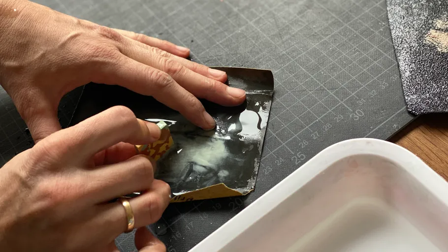 Hände entfernen Papier auf Arbeitsfläche.