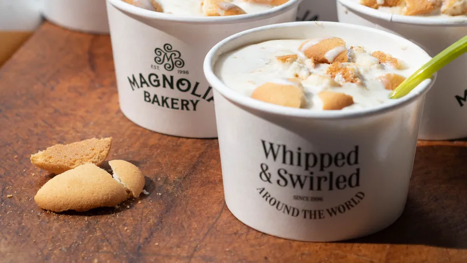 Dessert cups with cookies on wooden surface.