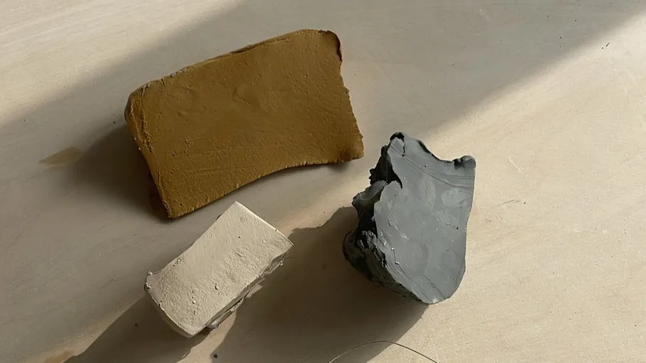 Three clay pieces on wooden surface.