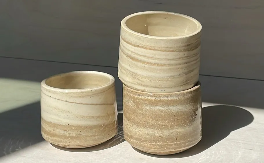 Three ceramic pots stacked on table.