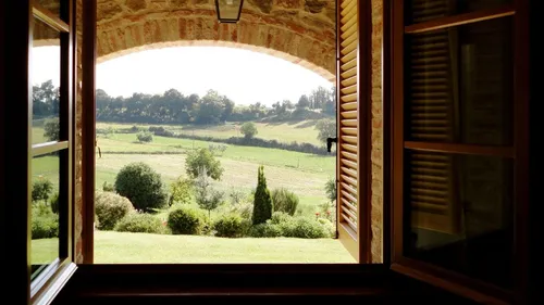 Offenes Fenster mit Blick auf grüne Landschaft.