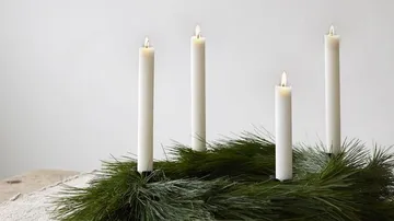 Vier Kerzen auf Tannenkranz, Holztisch.