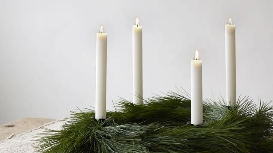 Vier Kerzen auf Tannenkranz, Holztisch.