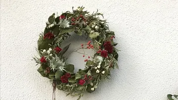 Decorative wreath with flowers on a wall.