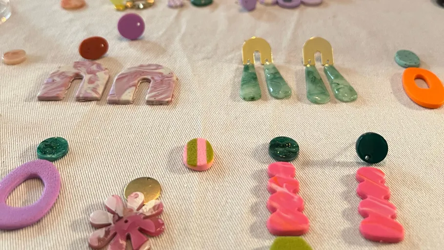 Colorful earrings displayed on white cloth.
