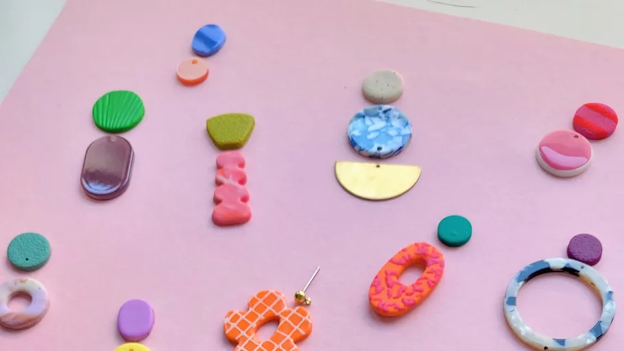 Colorful clay pieces on pink background.