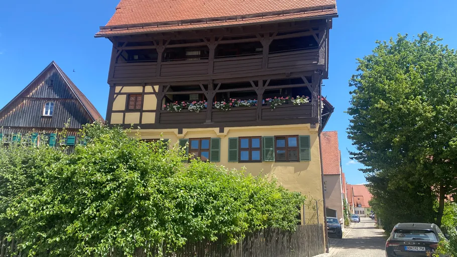 Fachwerkhaus mit Blumen in städtischer Umgebung.