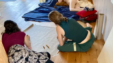 Two people draw a model in art studio.