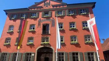 Red building with flags and wall artwork.