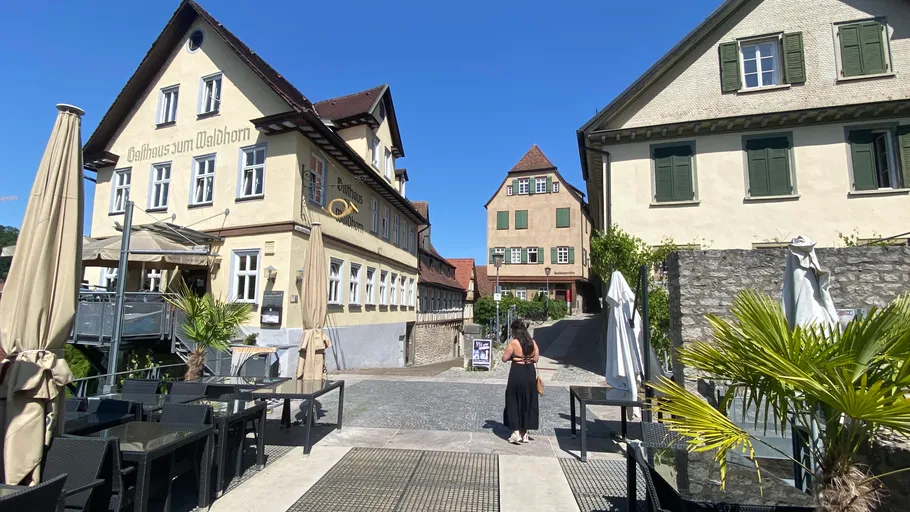 Person spaziert in sonnigem deutschen Dorf.